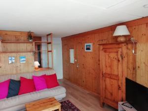 Una sala de estar con un sofá y un televisor. en Appartement 2 pièces cabine, 7 pers, Arc 1600, ski aux pieds, proche commerces, balcon sud - FR-1-411-669, en Arc 1600