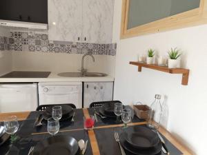 a kitchen with a table with plates and wine glasses at Appartement Saint-Lary-Soulan, 2 pièces, 6 personnes - FR-1-457-280 in Saint-Lary-Soulan