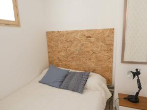 a bedroom with a white bed with a wooden headboard at Appartement Saint-Lary-Soulan, 2 pièces, 6 personnes - FR-1-457-280 in Saint-Lary-Soulan