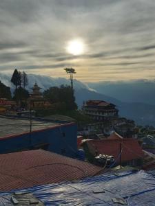 a view of a city with the sun in the sky at Hotel Sakura in Darjeeling