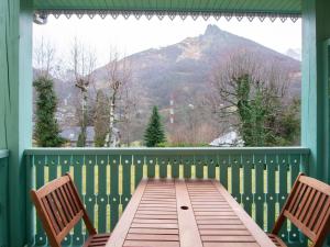 un tavolo e due sedie su un portico con una montagna di Chalet triplex pour 7 pers. avec terrasse, parking, proche télécabine et commerces - FR-1-401-178 a Cauterets Altre 2 foto