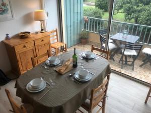 a table with plates and a bottle of wine on a balcony at Appartement Argelès-sur-Mer, 3 pièces, 6 personnes - FR-1-388-167 in Argelès-sur-Mer