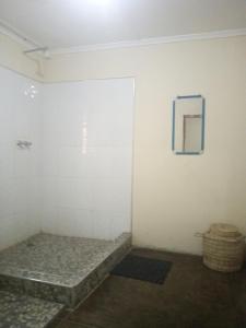a room with a white wall and a mirror at Blue Waxbill Lodge in Namzunga