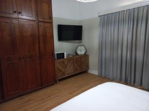 a bedroom with a bed and a flat screen tv at Karooland Gastehuis in Middelburg