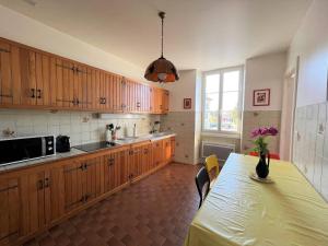 a kitchen with wooden cabinets and a table and a window at Appartement Cambo-les-Bains, 2 pièces, 3 personnes - FR-1-495-79 in Cambo-les-Bains