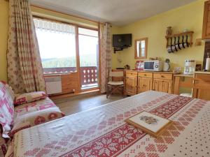 ein Schlafzimmer mit einem Bett und eine Küche mit einem Fenster in der Unterkunft Studio Notre-Dame-de-Bellecombe, 1 pièce, 2 personnes - FR-1-505-19 in Notre-Dame-de-Bellecombe