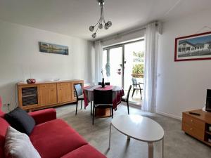 ein Wohnzimmer mit einem roten Sofa und einem Tisch in der Unterkunft Appartement 2 pers. RDC à Cambo-les-Bains avec Internet et Animaux admis - FR-1-495-62 in Cambo-les-Bains