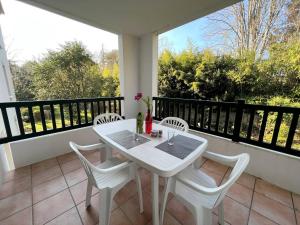 - Balcón con mesa blanca y sillas en Appartement Cambo-les-Bains, 2 pièces, 2 personnes - FR-1-495-57 en Cambo-les-Bains