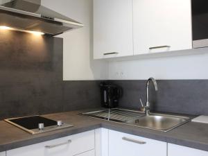 een keuken met witte kasten en een wastafel bij Appartement Pornichet, 2 pièces, 4 personnes - FR-1-245-132 in Pornichet
