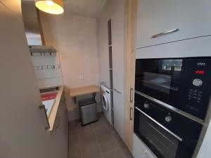 cocina pequeña con fogones y microondas en Appartement La Roche-Posay, 3 pièces, 4 personnes - FR-1-541-15, en La Roche-Posay