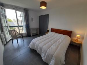 1 dormitorio con 1 cama, 1 silla y 1 ventana en Appartement La Roche-Posay, 3 pièces, 4 personnes - FR-1-541-15, en La Roche-Posay