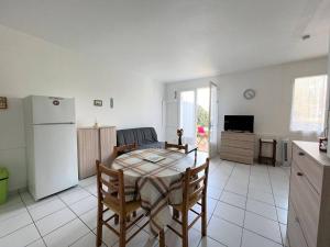 Il comprend une cuisine et une salle à manger avec une table et un réfrigérateur. dans l'établissement Appartement Cambo-les-Bains, 2 pièces, 3 personnes - FR-1-495-88, à Cambo-les-Bains