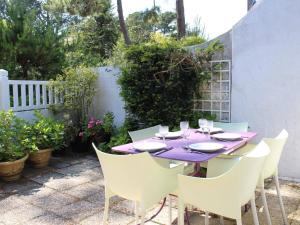 een paarse tafel met witte stoelen in een tuin bij Maison La Baule, 2 pièces, 4 personnes - FR-1-245-115 in La Baule
