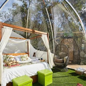 een slaapkamer met een bed en een stoel in een tent bij BubbleSky Glamping 40 min from Medellin in El Retiro
