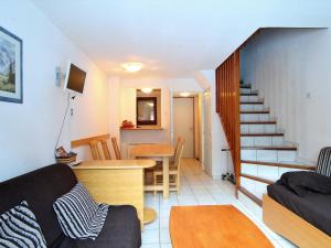 ein Wohnzimmer mit einem Sofa, einem Tisch und einer Treppe in der Unterkunft Appartement La Salle-les-Alpes, 3 pièces, 6 personnes - FR-1-330F-194 in La Salle Les Alpes