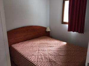 une chambre avec un lit dans une pièce avec une fenêtre dans l'établissement Duplex 7 pers. avec parking, piscine, fitness, proche pistes - La Mongie - FR-1-404-205, à La Mongie 6 autres photos