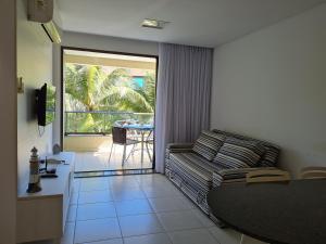 sala de estar con sofá y mesa en Flat Praia Dos Carneiros en Tamandaré