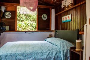 a bedroom with a bed and a window at Chalet Y Cabinas Hibiscus in Cahuita