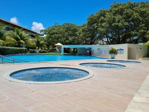 a swimming pool with two circular pools on a patio at Flat Praia Dos Carneiros in Tamandaré