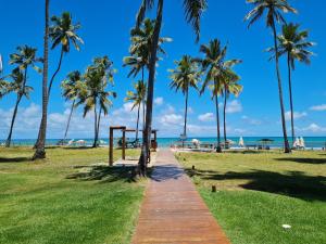 un camino que conduce a la playa con palmeras en Flat Praia Dos Carneiros en Tamandaré