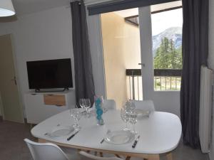 a white table with chairs and wine glasses on it at Appartement Montgenèvre, 2 pièces, 6 personnes - FR-1-266-145 in Montgenèvre