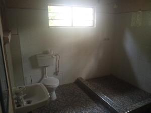 baño pequeño con aseo y ventana en Blue Waxbill Lodge, en Namzunga