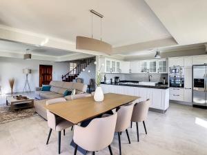 a kitchen and living room with a wooden table and chairs at Villa Baradaye by LovelyStay in Estreito da Calheta