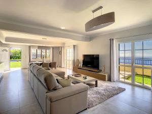 a living room with a couch and a tv at Villa Baradaye by LovelyStay in Estreito da Calheta