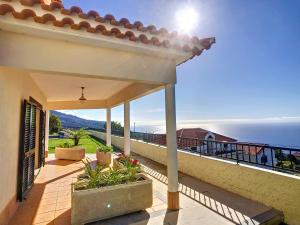 a balcony of a house with a view of the ocean at Villa Baradaye by LovelyStay in Estreito da Calheta