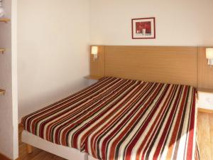 una camera da letto con un letto con una coperta a righe di Appartement Les Orres, 3 pièces, 8 personnes - FR-1-322-378 a Les Orres