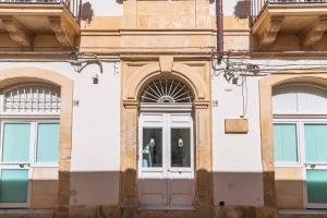 budynek z dwoma drzwiami i dwoma oknami w obiekcie A'Storia w Syrakuzach