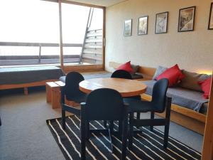 a room with a table and chairs and a couch at Studio pour 4 à Arc 1600 proche des pistes et commerces - FR-1-411-625 in Arc 1600