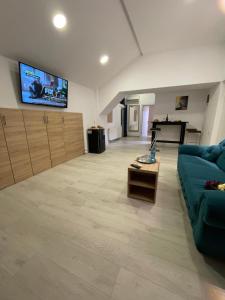 a living room with a blue couch and a flat screen tv at Floria Hotels in Voluntari +6 photos