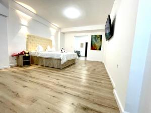 a bedroom with a bed and a flat screen tv at Floria Hotels in Voluntari