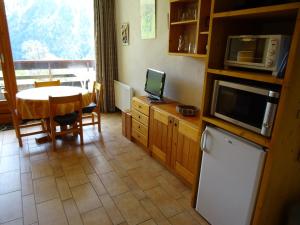 a kitchen with a table and a microwave and a dining room at Studio Peisey-Nancroix-Plan Peisey, 1 pièce, 4 personnes - FR-1-411-641 in Peisey-Nancroix