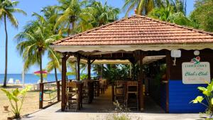 - un restaurant sur la plage avec des palmiers dans l'établissement Imperatrice Village - Résidence sur la plage, à Les Trois-Îlets