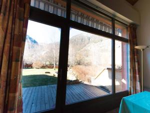 ein großes Fenster mit Blick auf eine Holzterrasse in der Unterkunft Maison La Salle-les-Alpes, 4 pièces, 10 personnes - FR-1-330F-3 in La Salle Les Alpes