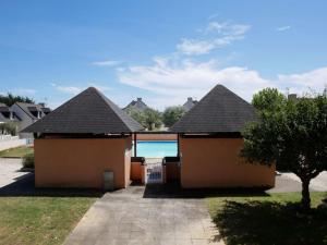 a house with three roofs with a swimming pool at Appartement Erdeven, 2 pièces, 4 personnes - FR-1-479-106 in Erdeven