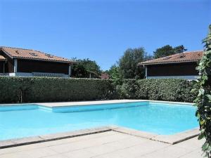 a large blue swimming pool in front of a house at Villa Capbreton, 4 pièces, 6 personnes - FR-1-413-114 in Capbreton
