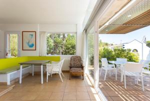 卡萊利亞德帕拉弗魯赫爾的住宿－Luxury Villa in front of the beach POPETA，一间带桌椅和窗户的用餐室