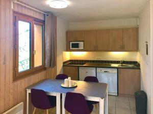 a kitchen with a table with purple chairs and a table and a kitchen with at Appartement Les Orres, 2 pièces, 4 personnes - FR-1-322-370 in Les Orres