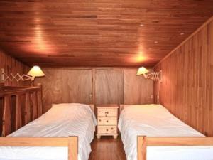 2 Betten in einem Zimmer mit Holzwänden in der Unterkunft Appartement Montgenèvre, 3 pièces, 6 personnes - FR-1-266-157 in Montgenèvre