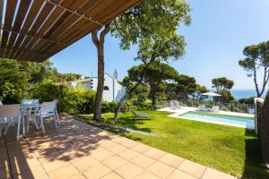 卡萊利亞德帕拉弗魯赫爾的住宿－Luxury Villa in front of the beach POPETA，从带游泳池的房屋的庭院欣赏美景