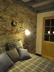 ein Schlafzimmer mit einem Bett mit einer Steinmauer in der Unterkunft Le Cottage in Saint-Sébastien-sur-Loire