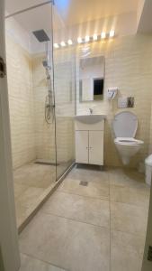a bathroom with a toilet and a sink and a shower at Floria Hotels in Voluntari