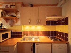 a kitchen with a sink and a microwave at Studio divisible, balcon, animaux acceptés, casier à skis, linge de lit inclus - FR-1-291-839 in Valmorel +3 photos