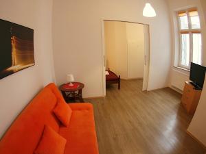 ein Wohnzimmer mit einem orangenen Sofa und einem Tisch in der Unterkunft VisitKrak in Krakau