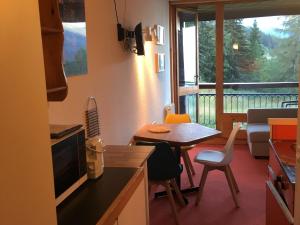 a kitchen with a table and a dining room with a balcony at Studio Les Arcs 1800, 1 pièce, 4 personnes - FR-1-411-642 in Arc 1800