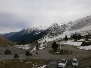 un aparcamiento con coches estacionados frente a una montaña cubierta de nieve en Studio Piau-Engaly, 1 pièce, 6 personnes - FR-1-457-212, en Aragnouet