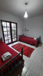 1 dormitorio con 2 camas y alfombra roja en Nieva 4M en San Salvador de Jujuy